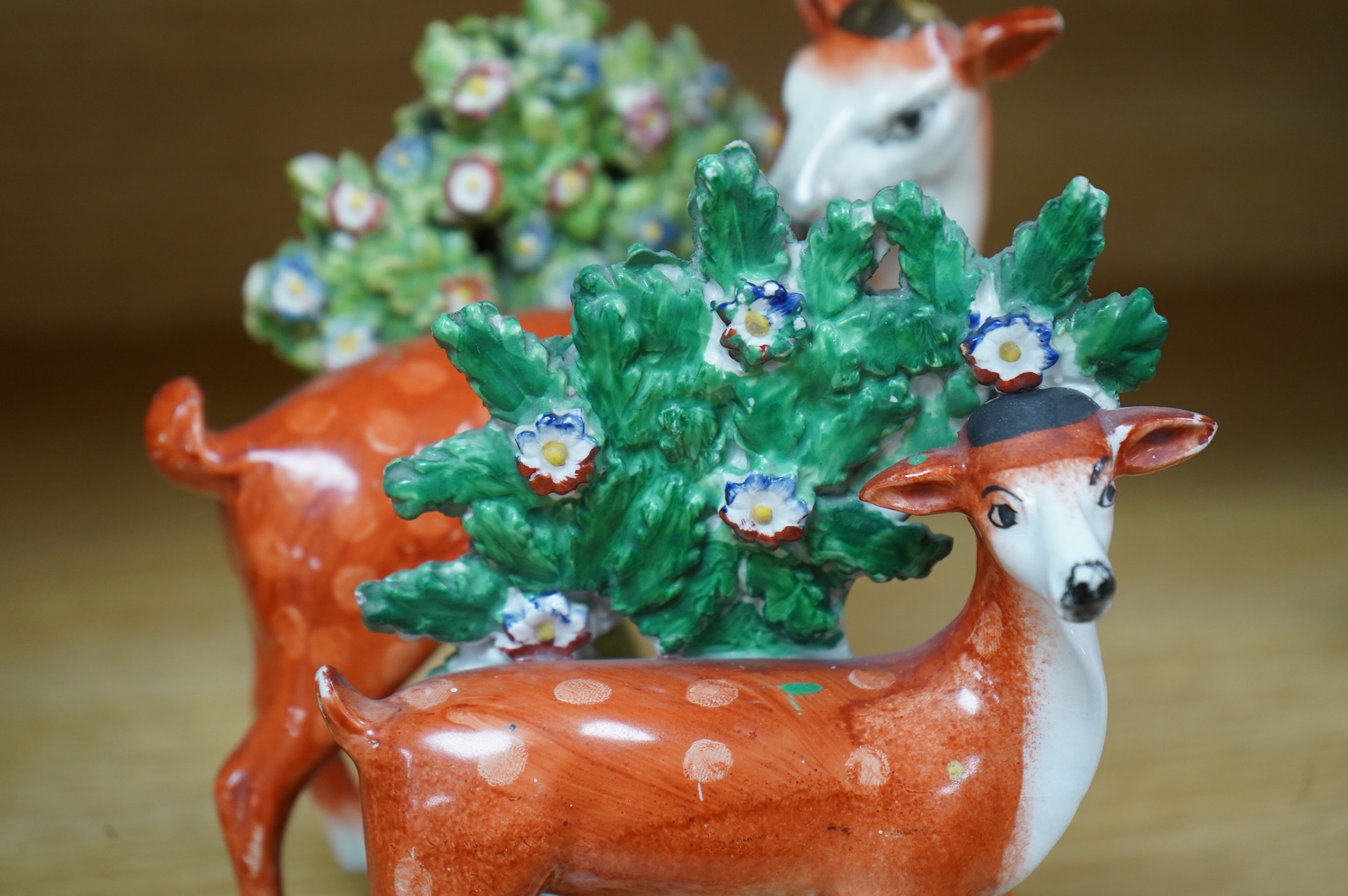Three early 19th century Staffordshire pottery models of deer, largest 16cm high
